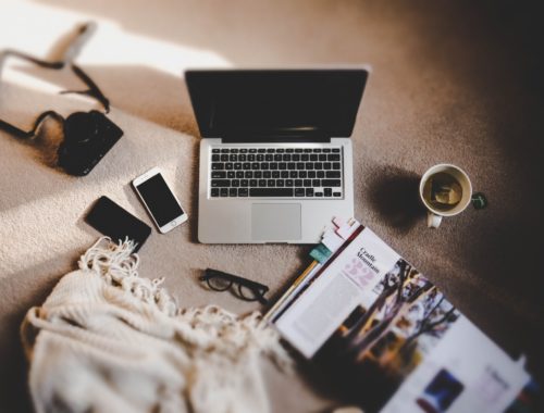 laptop con rivista e occhiali
